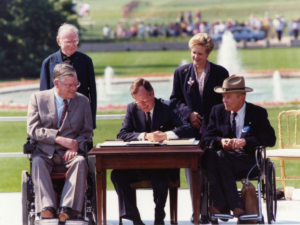 George Bush signs the Americans with Disabilities Act into law in 1990.